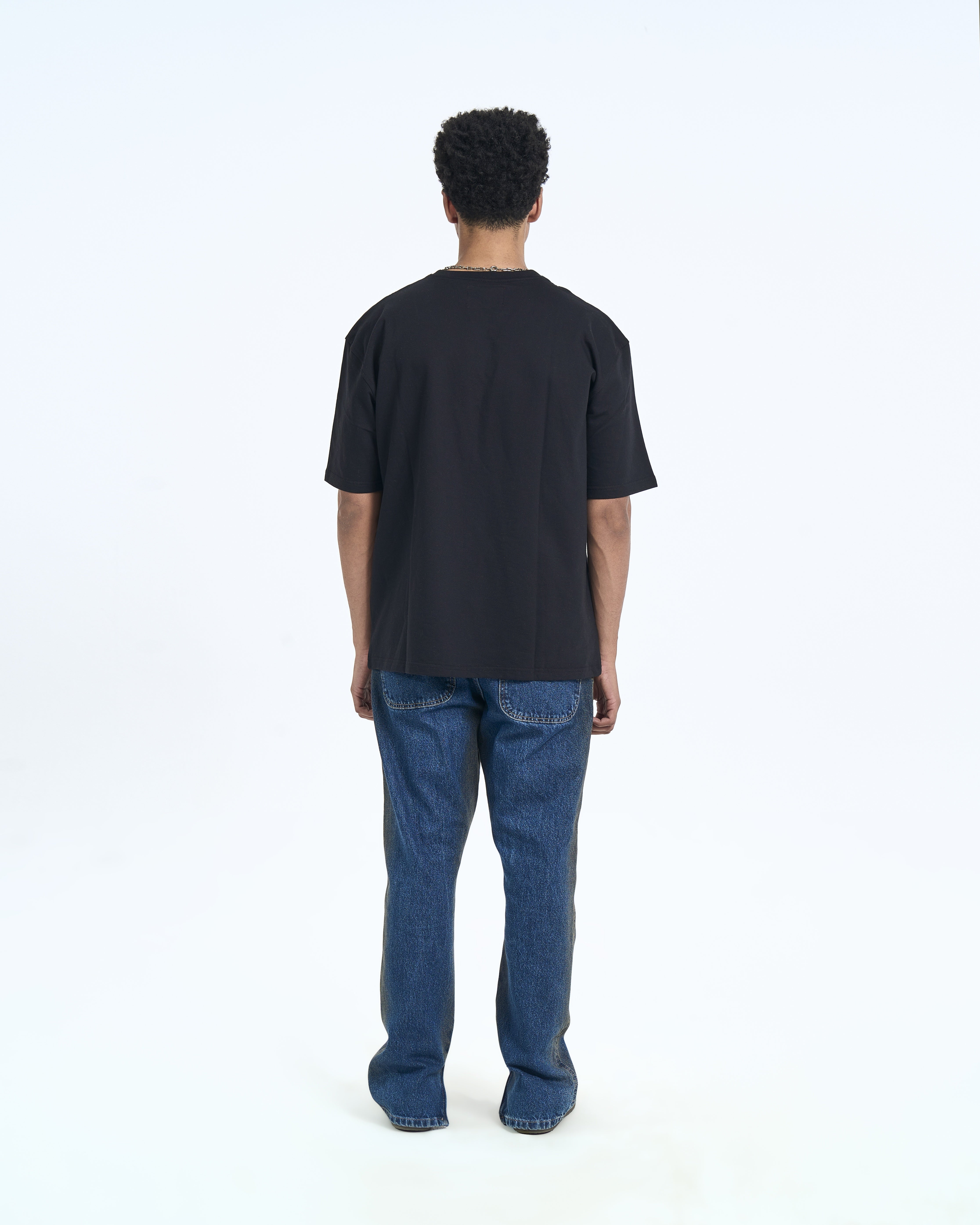 MOE CHARLIE Basic T-Shirt Schwarz – Rückenansicht Herrenmodel, cleane Silhouette, blaue Carpenter-Jeans
