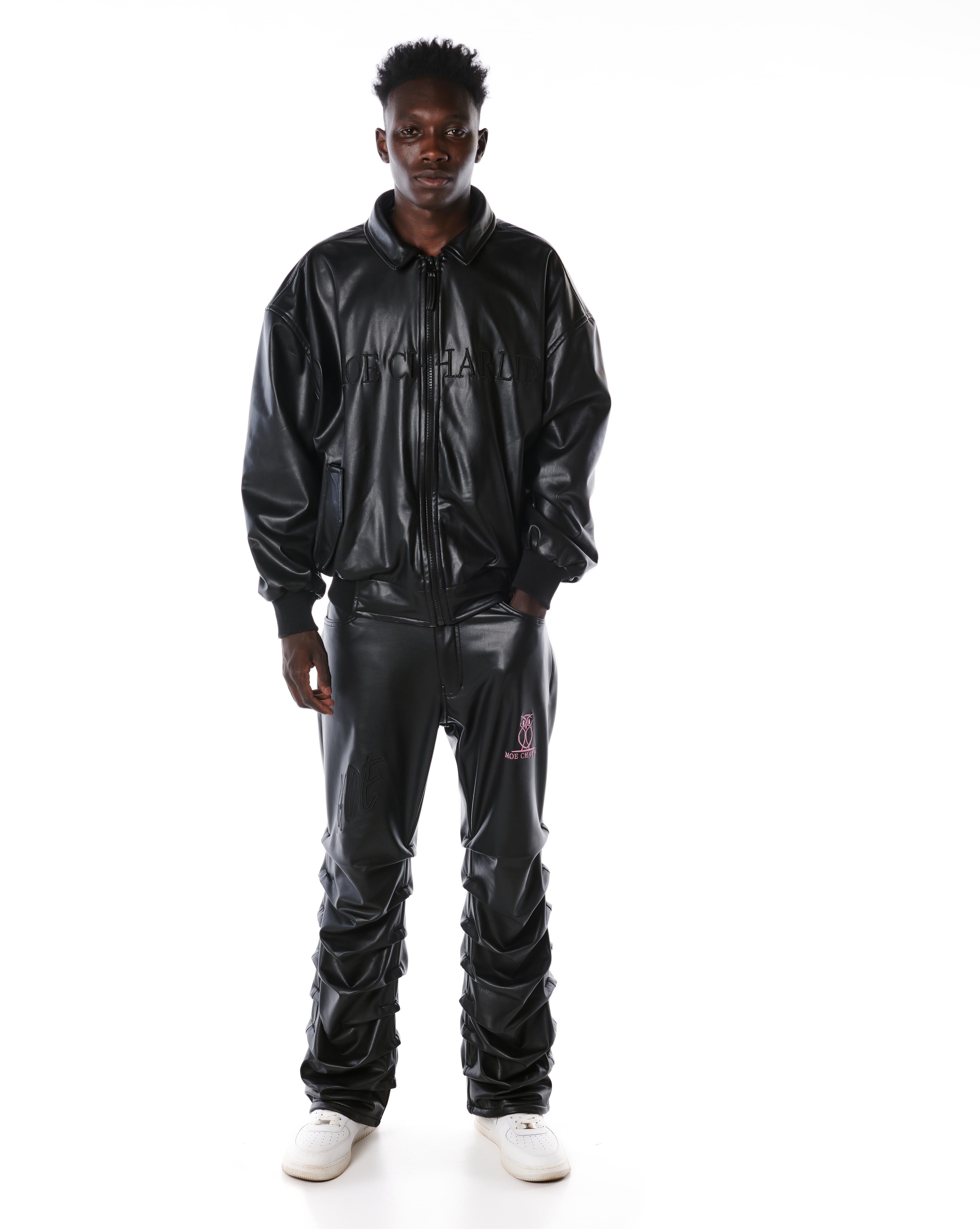 MOE CHARLIE Lederhose Schwarz, Frontansicht mit Lederjacket, Stacked-Fit und rosa Owl-Logo am Oberschenkel