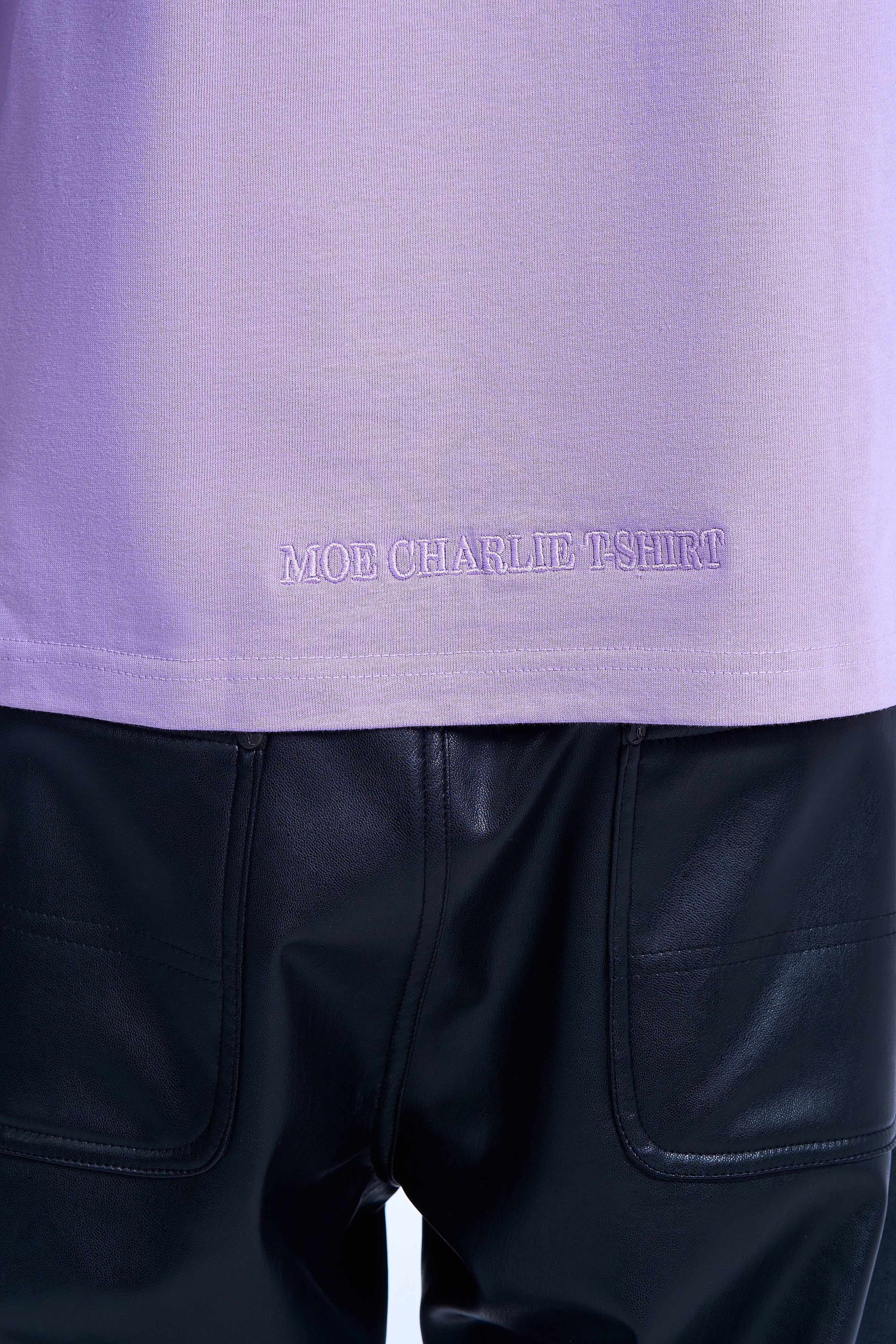 Detailaufnahme Saum-Stickerei MOE CHARLIE Lavendel Tee – Schriftzug MOE CHARLIE T-SHIRT ton-in-ton bestickt