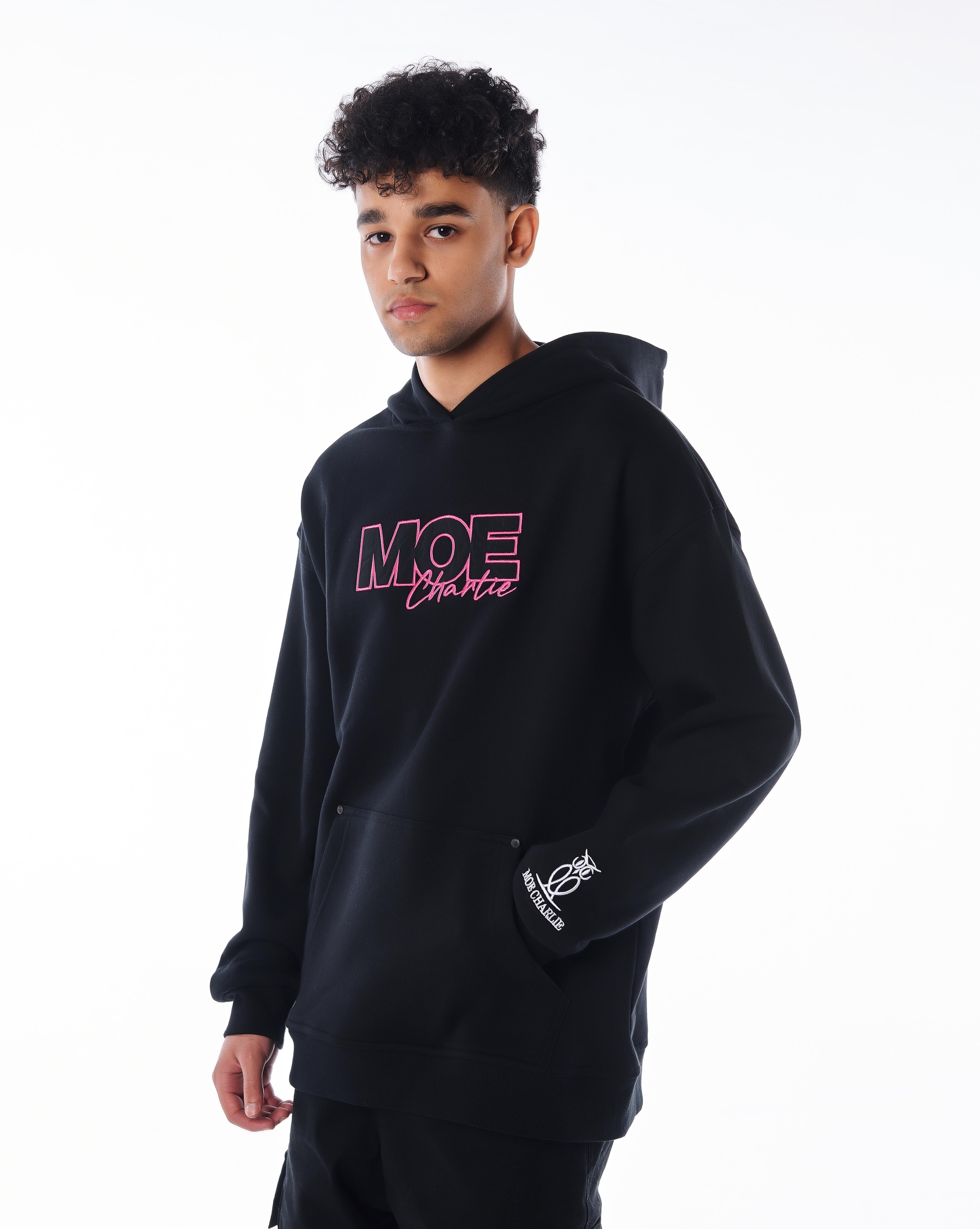 Dreiviertelansicht links MOE CHARLIE Pink Passion Hoodie, pinke Brust-Stickerei, Eulen-Logo am Ärmel sichtbar