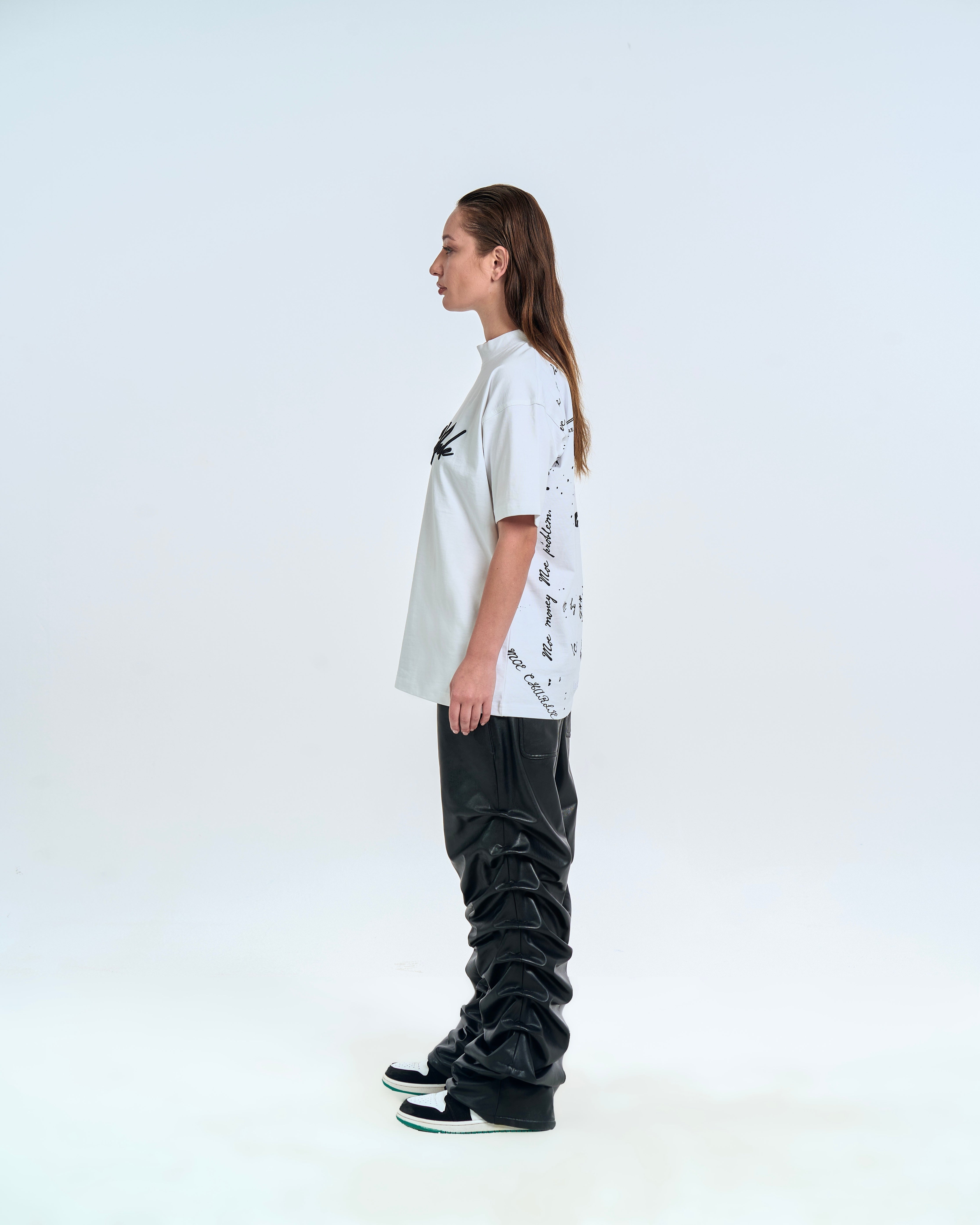 Seitenansicht weiblicher Model MOE CHARLIE Self Made – Graffiti-Rückenprint seitlich erkennbar, schwarze Leather-Pants