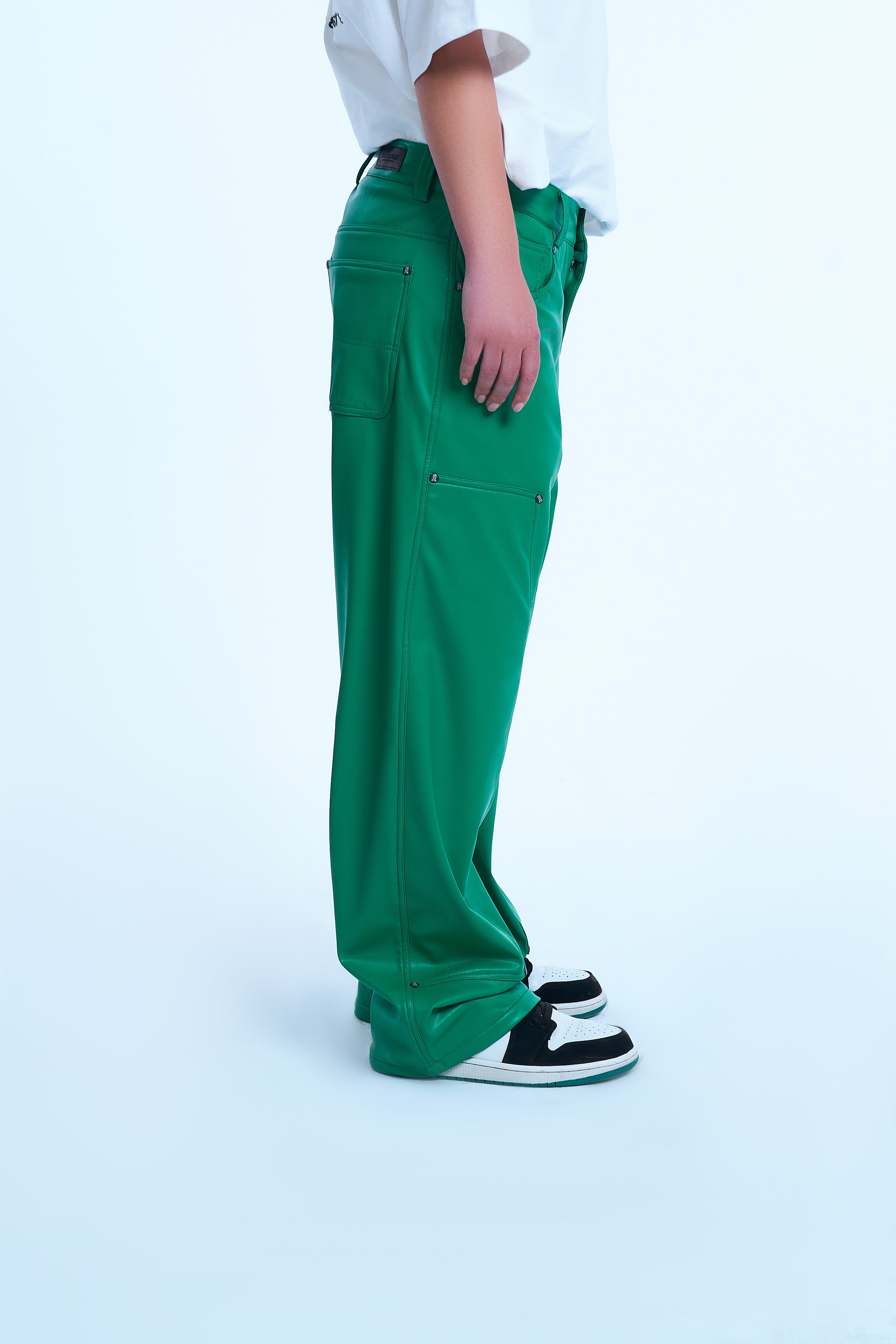 Gruene Carpenter Leather Pants von MOE CHARLIE, Seitenansicht weiblich, luftige weite Passform und Sneakers