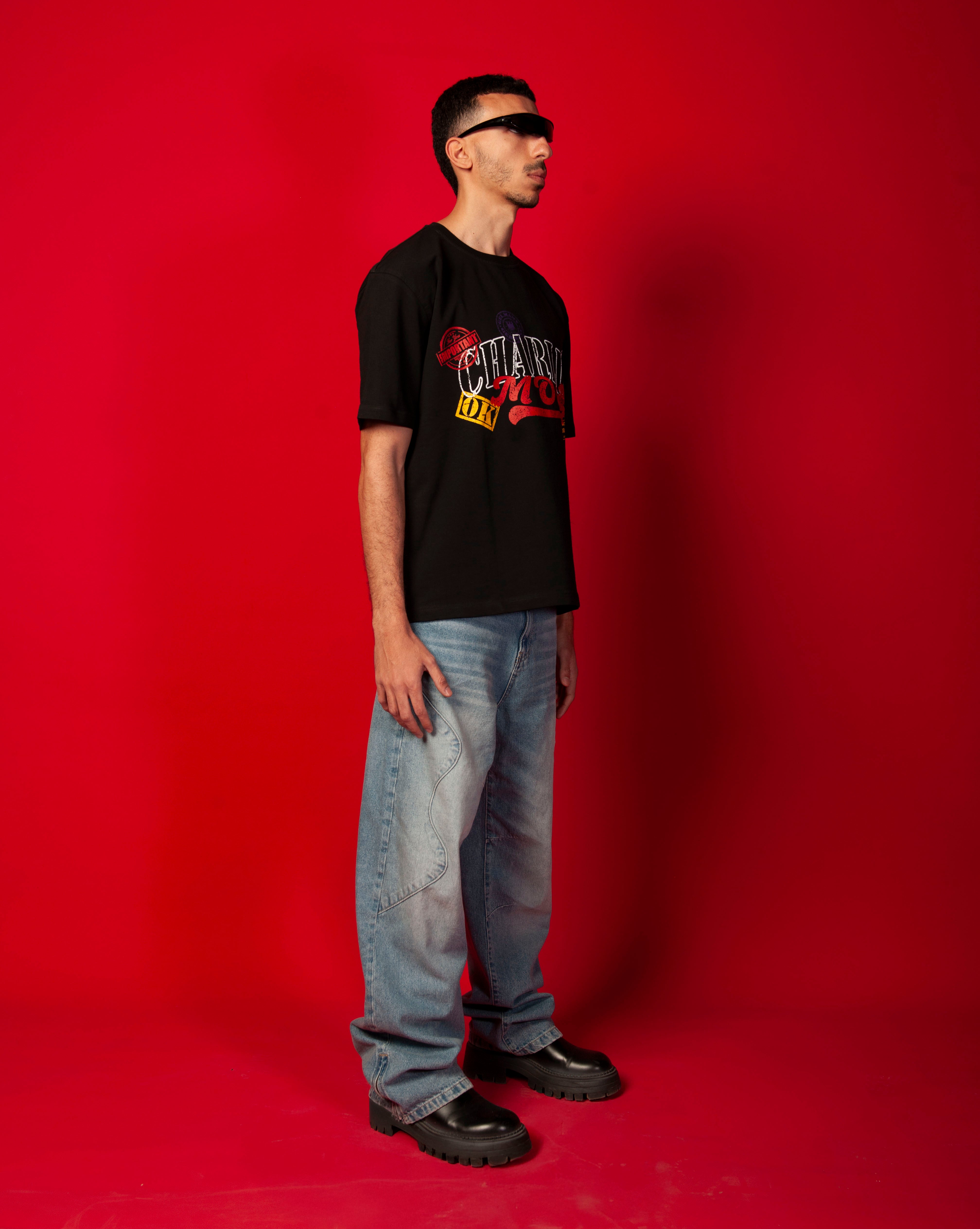 MOE CHARLIE Stampel T-Shirt, Seitenansicht maennlich, schwarzes Oversize-Tee mit Stempel-Print, rotes Studiofoto