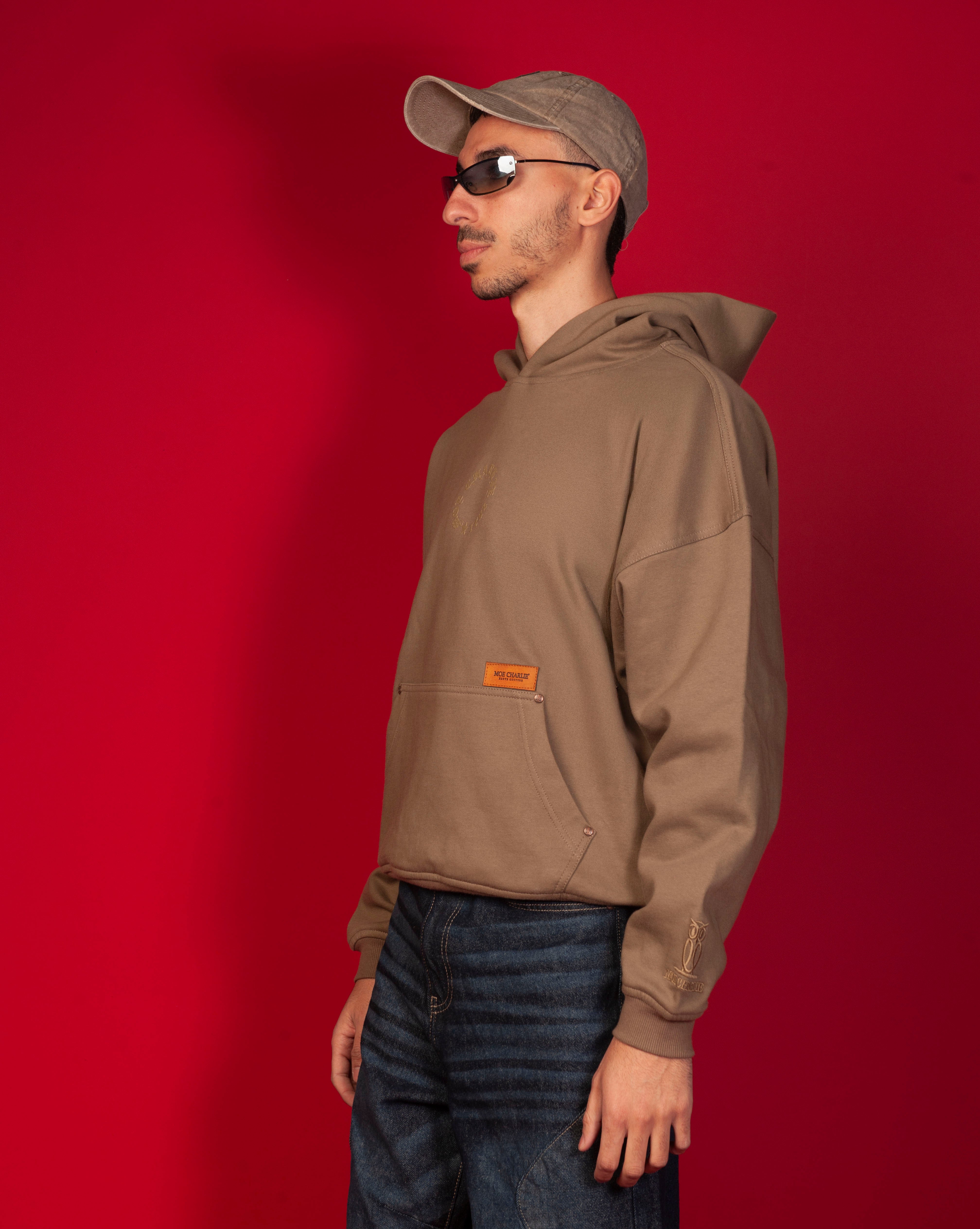 MOE CHARLIE Hoodie Seitenansicht maennlich, caramel Leder-Label und tonal gesticktes Owl-Logo am Aermelbund