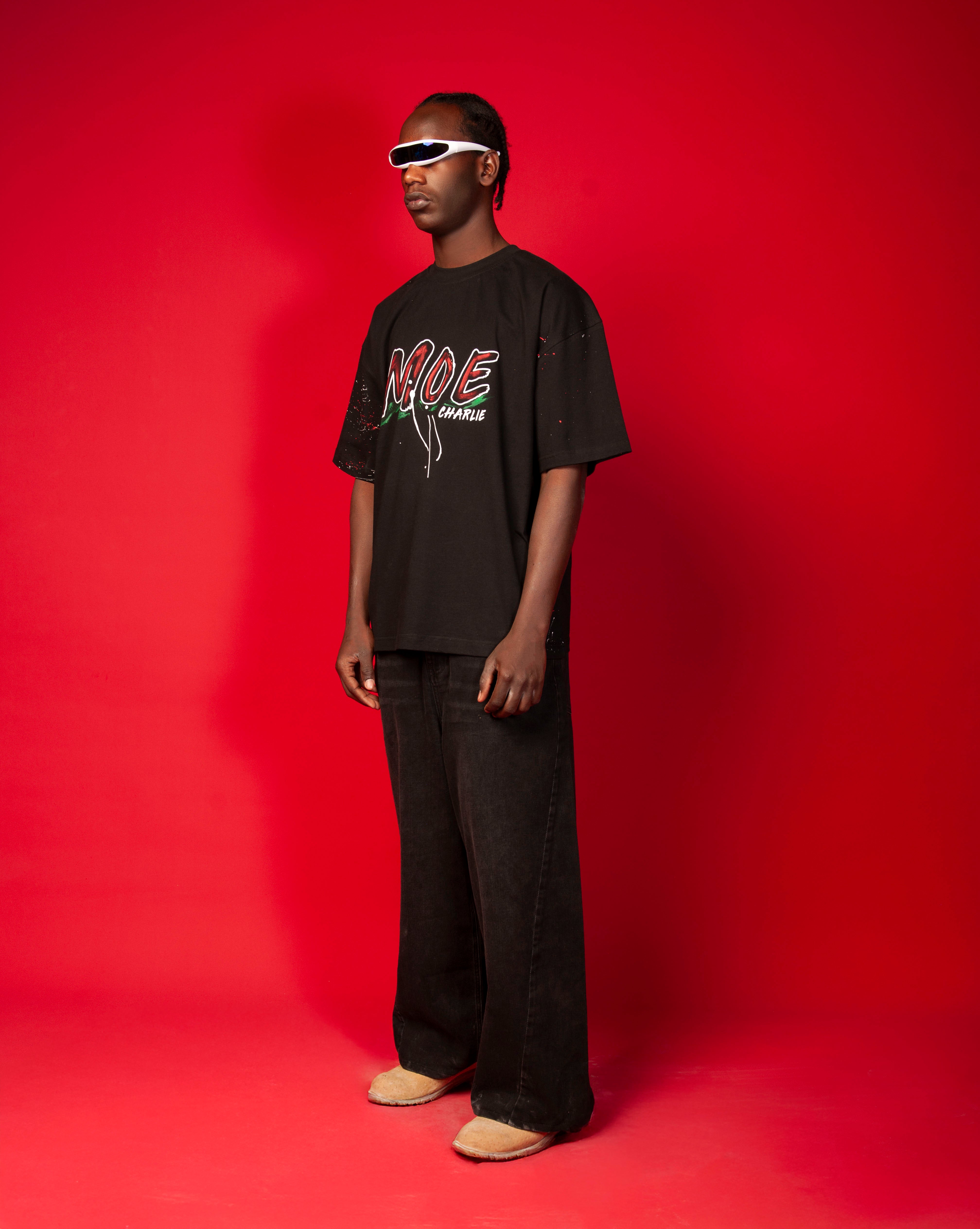 MOE CHARLIE Moe T-Shirt Schwarz, seitliche Frontansicht, schwarzes Graffiti-Tee mit rotem MOE-Print, weite schwarze Hose