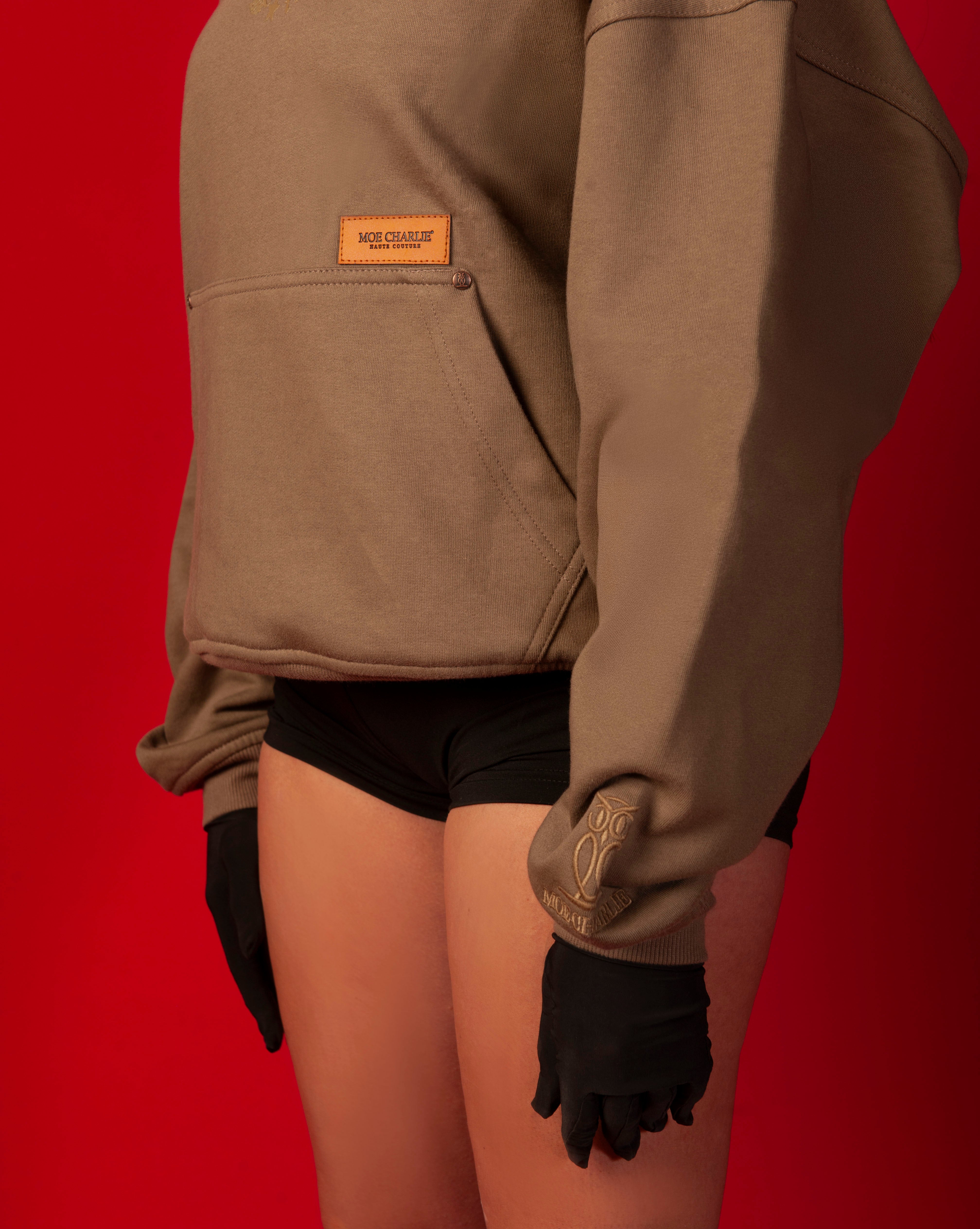 Detailaufnahme MOE CHARLIE Hoodie, caramel Leder-Label-Patch und tonal gesticktes Owl-Logo am Aermelbund