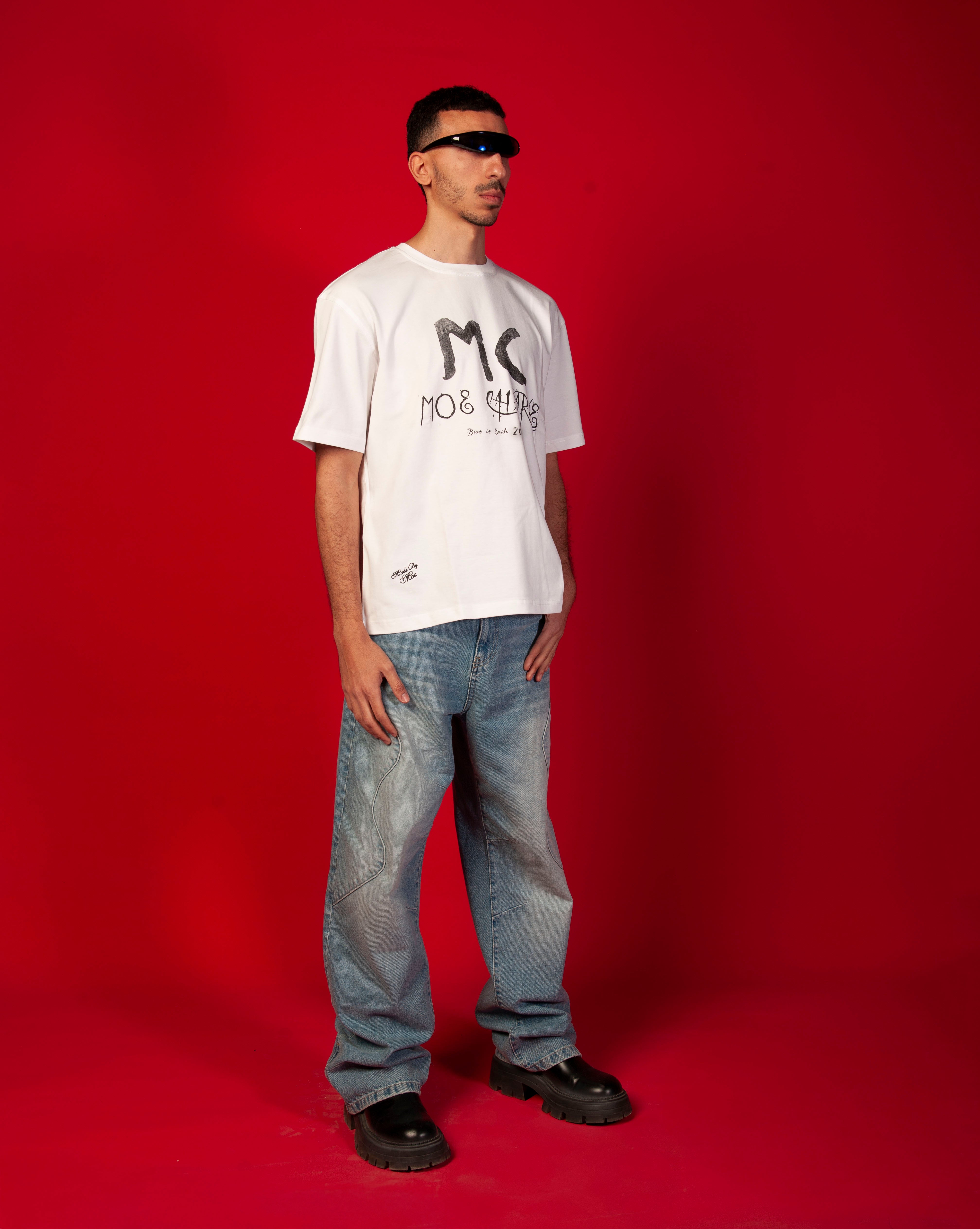MOE CHARLIE MC T-Shirt, Seitenansicht maennlich Ganzkoerper, weisses Oversize-Tee, Hand an Koerperseite, helle Jeans