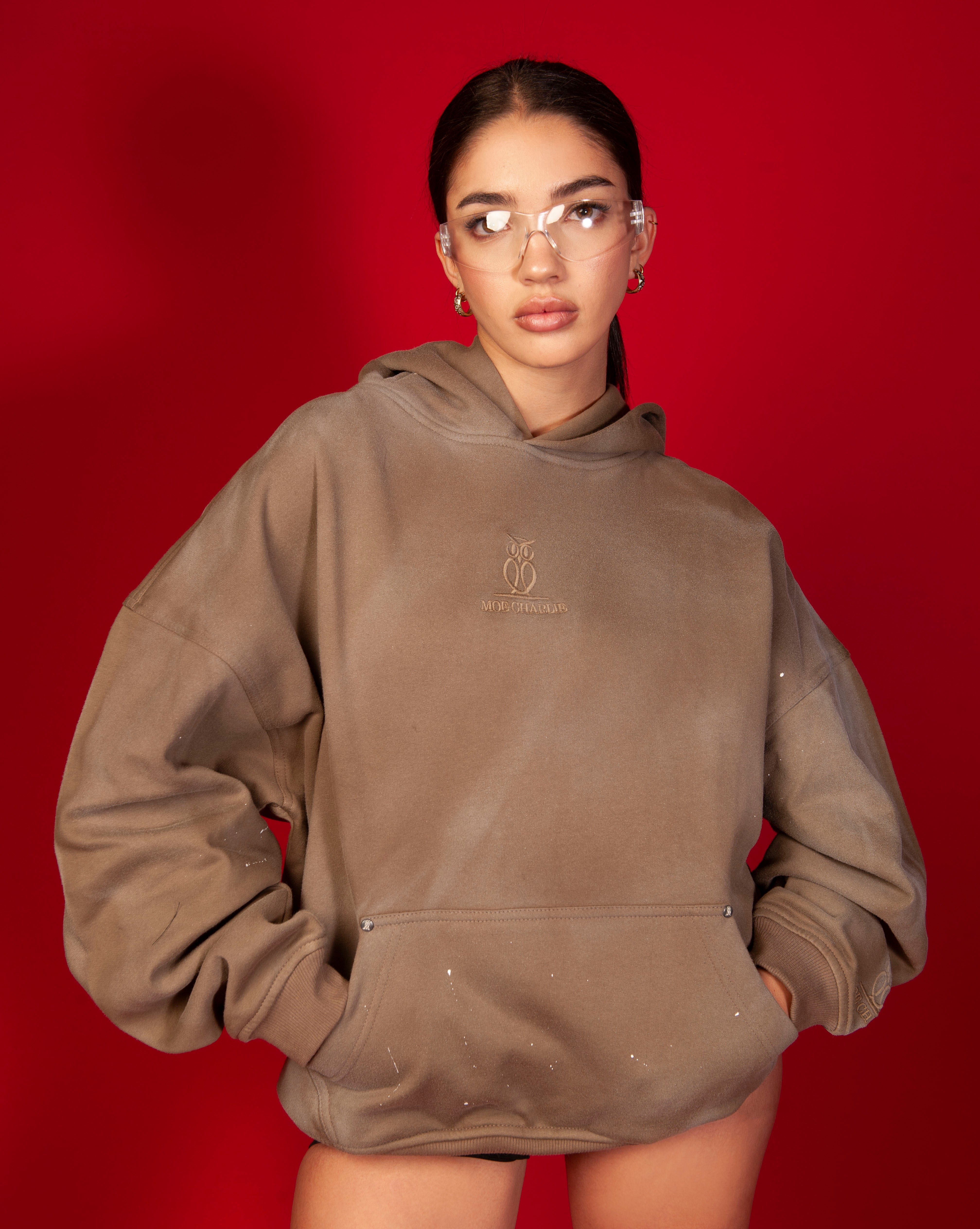 MOE CHARLIE Artist Hoodie Frontansicht weiblich, tonal gesticktes Owl-Logo, silberne Nieten an Kanguru-Tasche