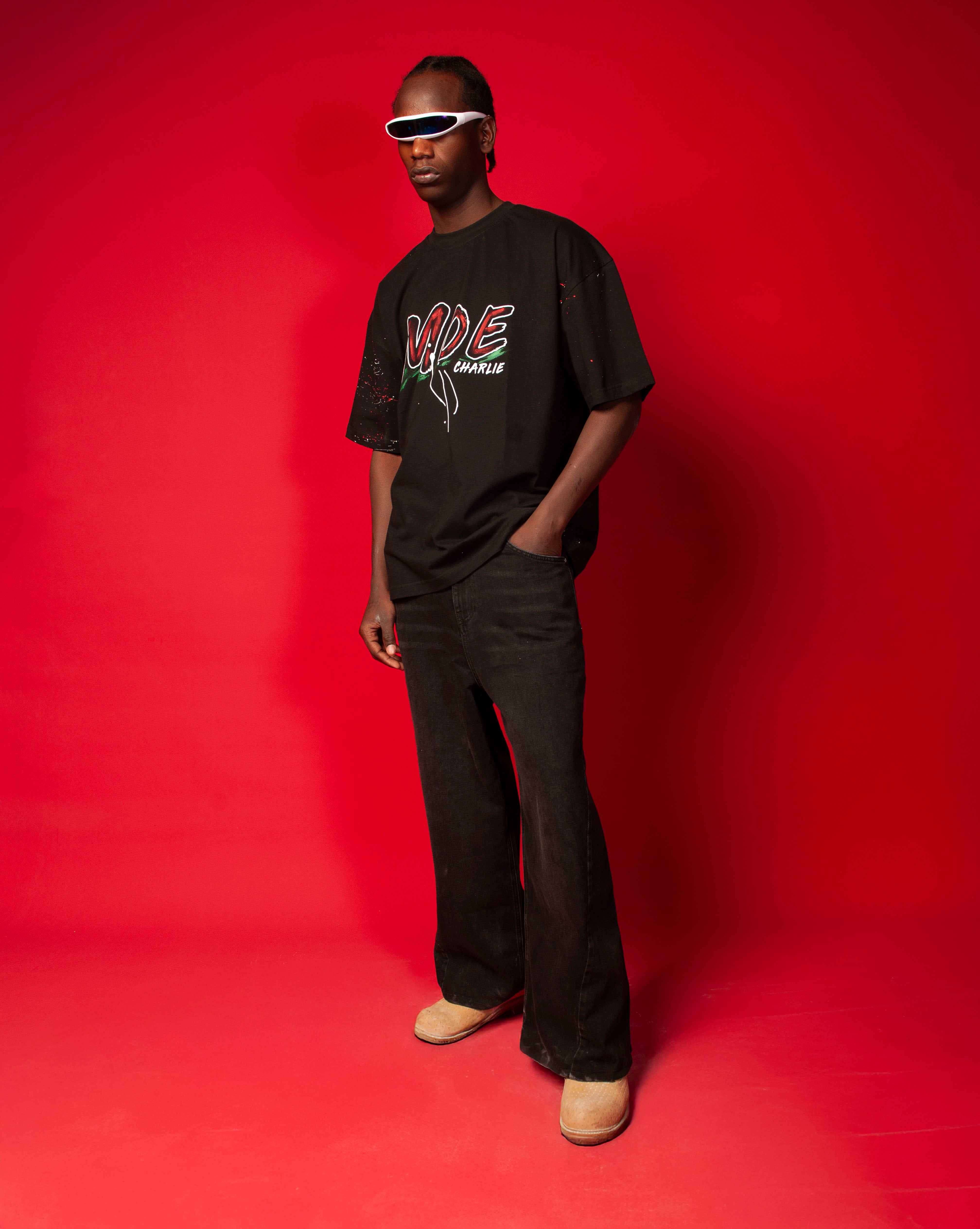 Moe T-Shirt Schwarz MOE CHARLIE, Hand in Tasche, roter Graffiti-MOE-Print, weite schwarze Jeans und blauer Visor