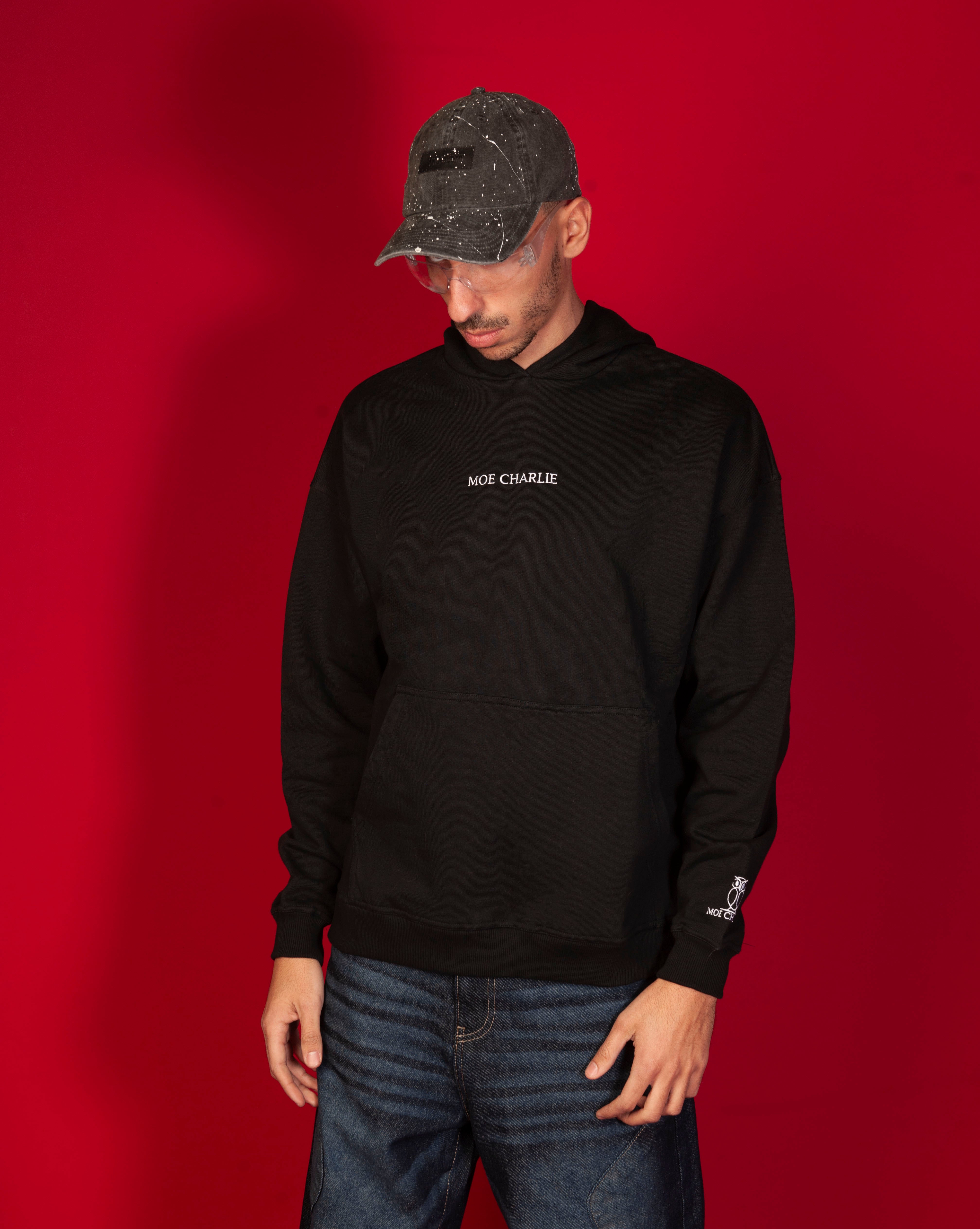 Basic 460 Hoodie MOE CHARLIE, maennlich Dreiviertelansicht, schwarzer Hoodie mit weissem Schriftzug, Destroyed-Cap