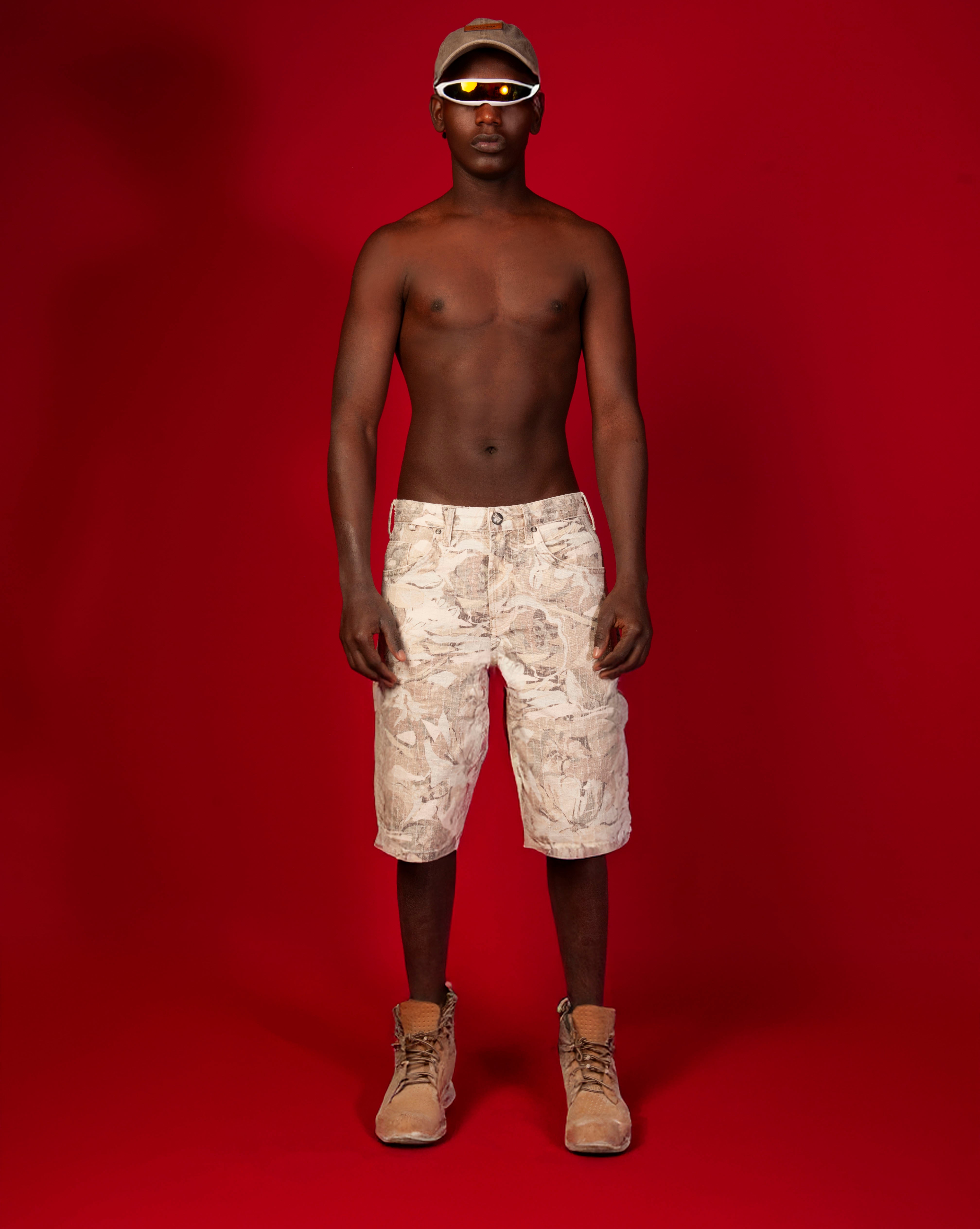 MOE CHARLIE Baggy Jorts, Frontansicht maennlich, abstrakter Allover-Print, Kappe, orangefarbene Brille
