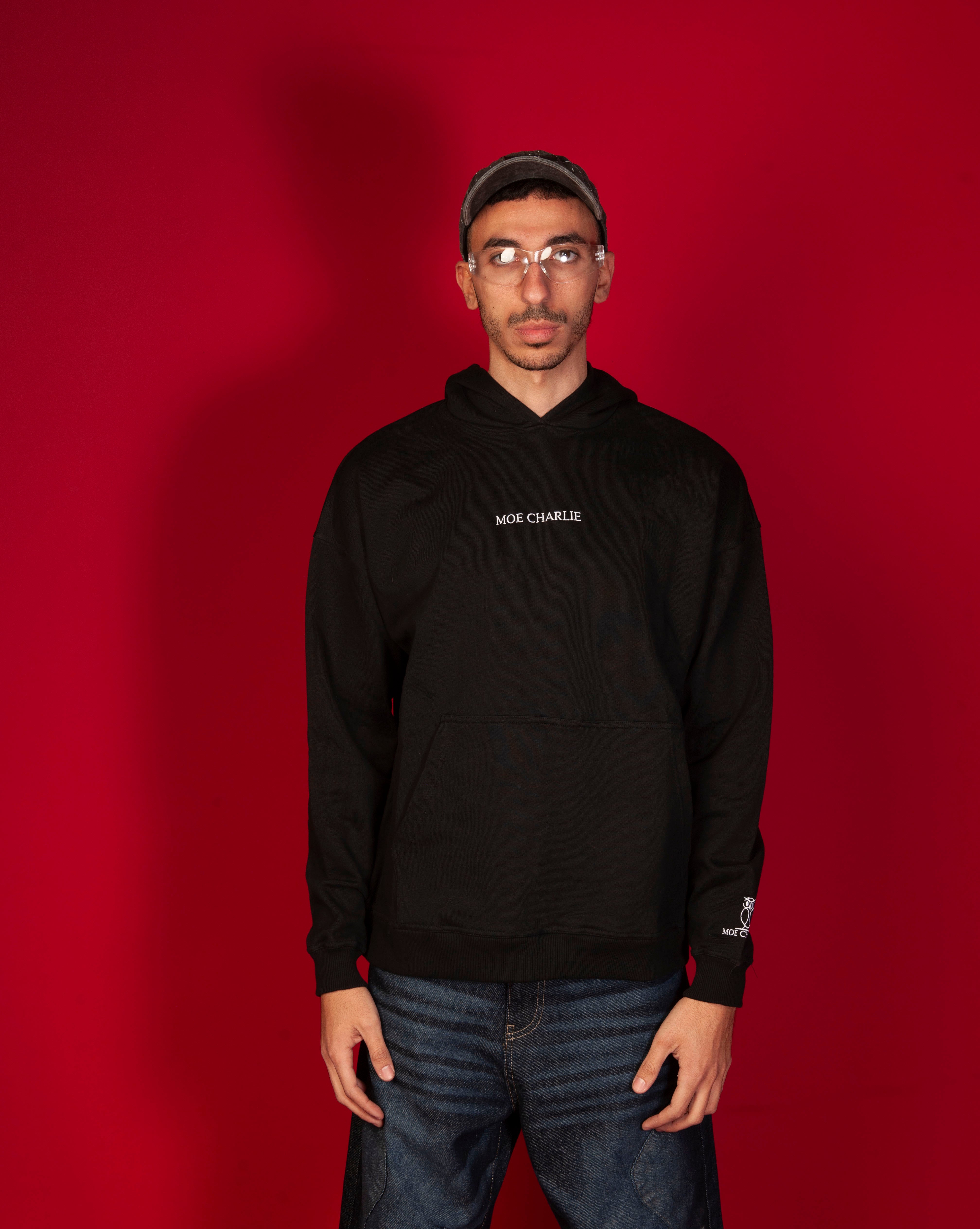 MOE CHARLIE Basic 460 Hoodie, Frontansicht maennlich, schwarzer Oversize-Hoodie mit weissem Stick, Jeans