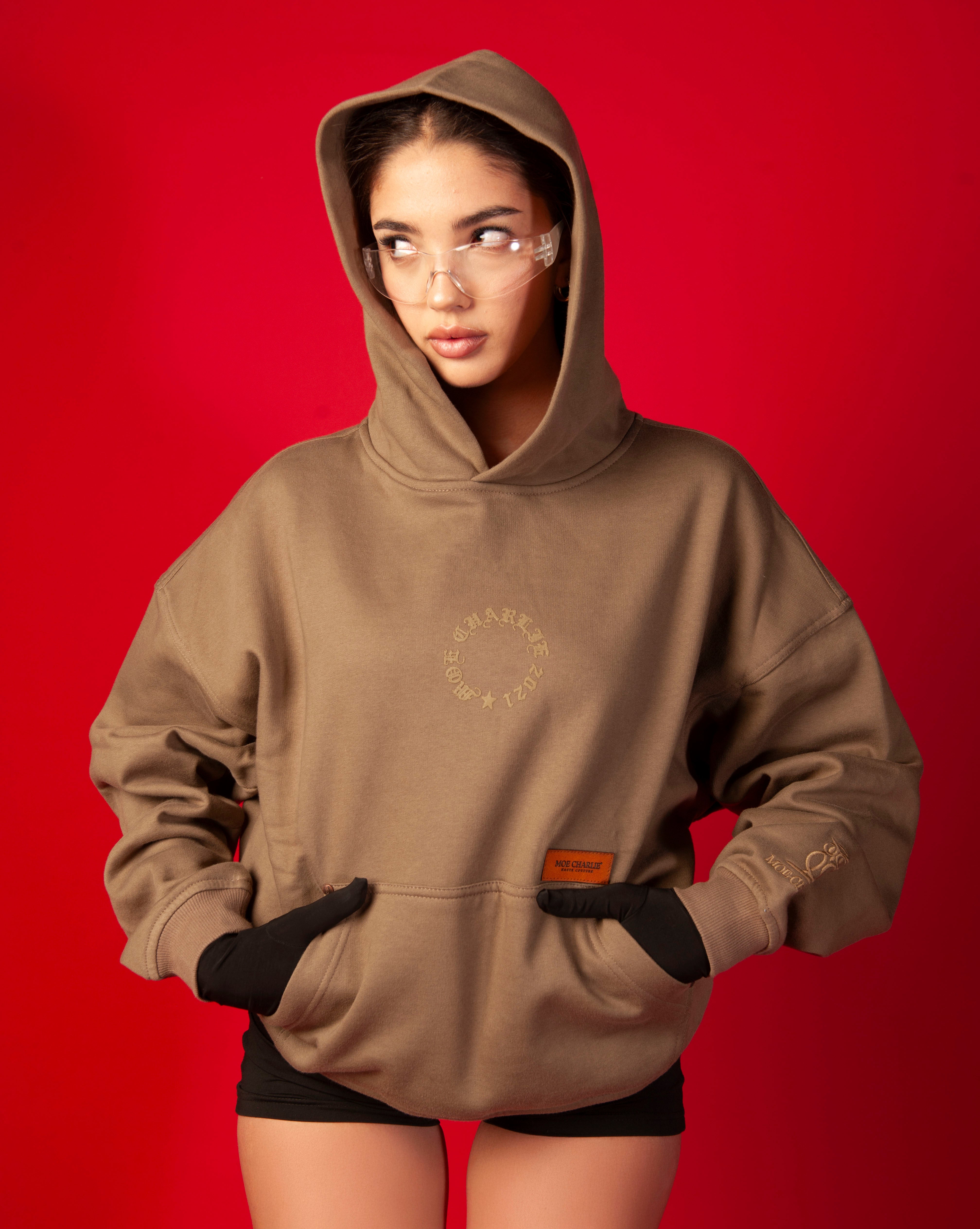 Moe Charlie Hoodie MOE CHARLIE weiblich, Frontansicht mit Kapuze, Schild-Brille, schwarze Handschuhe und Shorts