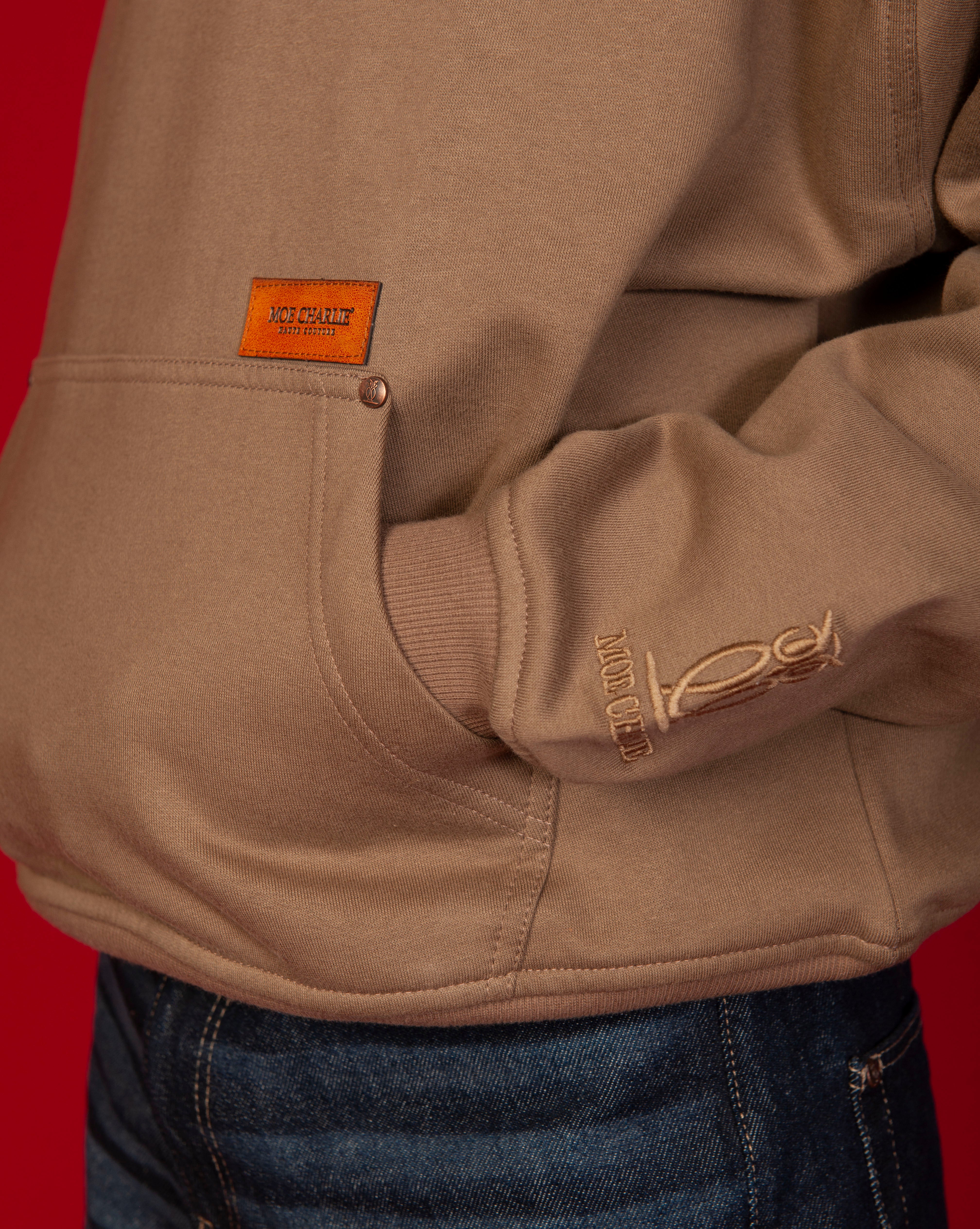 Nahaufnahme Kangoeru-Tasche Moe Charlie Hoodie MOE CHARLIE, caramel Leder-Label und Owl-Aermelbund-Stickerei