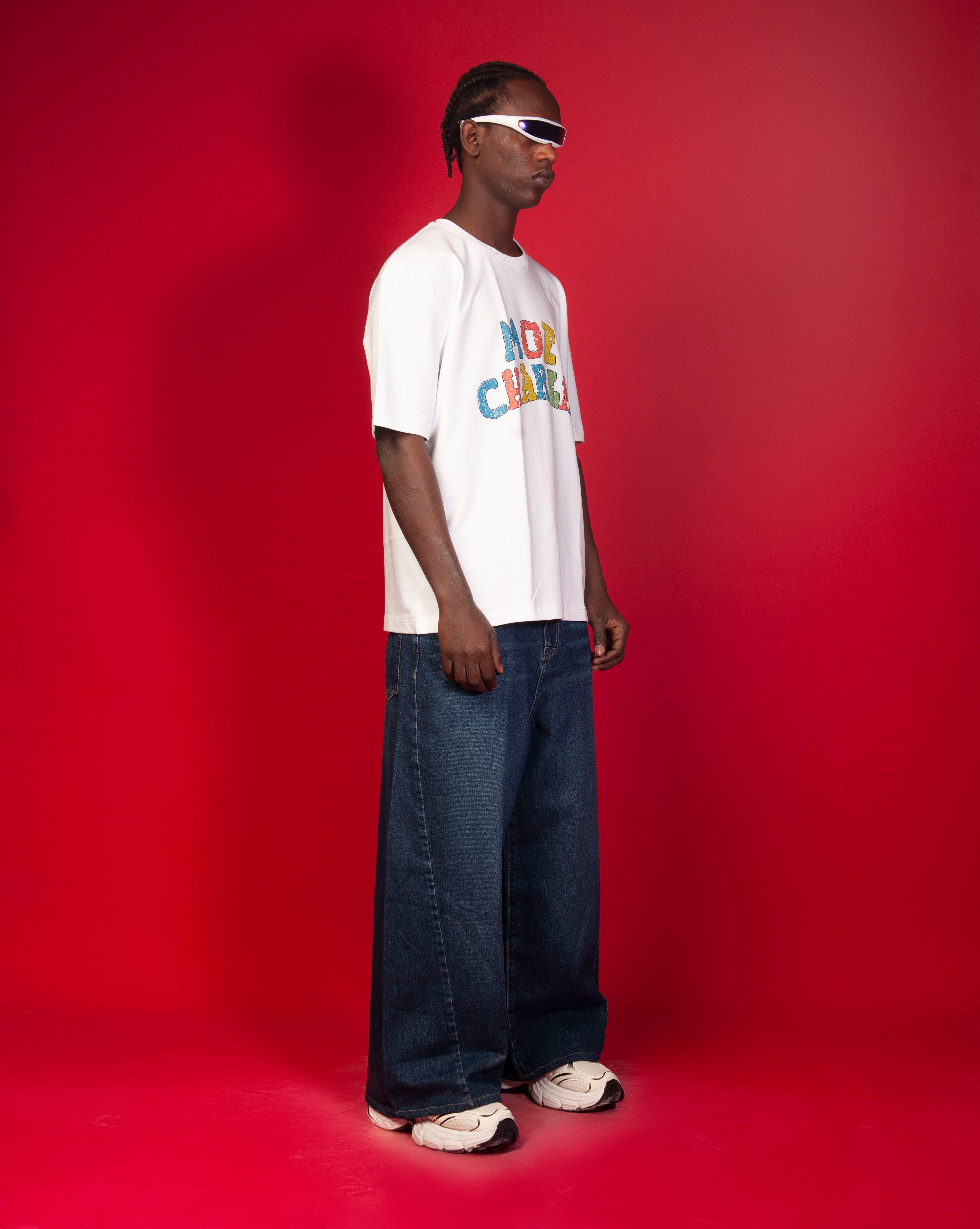 Seitenansicht Google T-Shirt MOE CHARLIE Ganzkoerper, maennlich, bunter Block-Print und ultra-weite dunkle Jeans
